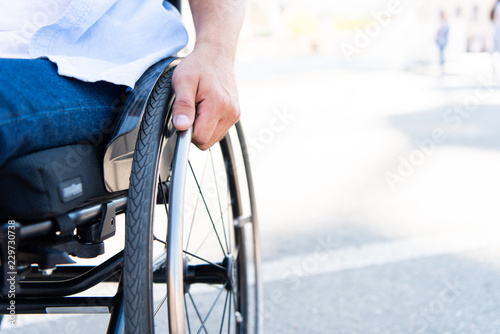 cropped image of man using wheelchair on street