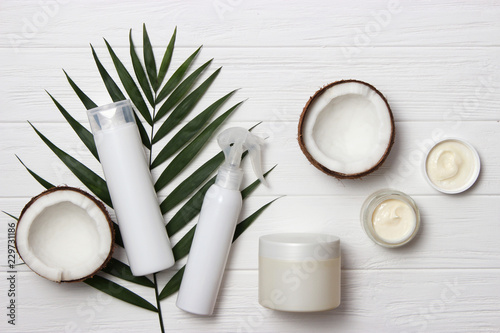 Tropical leaf  care cosmetics and coconut on a wooden table. Top view. Means for hair  body  skin. flatlay