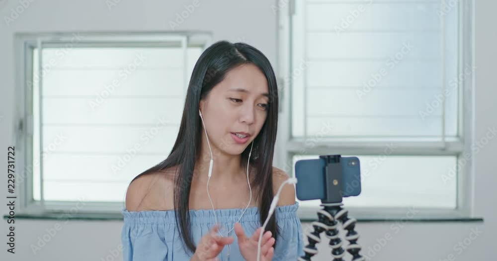 Woman having live stream on cellphone at home
