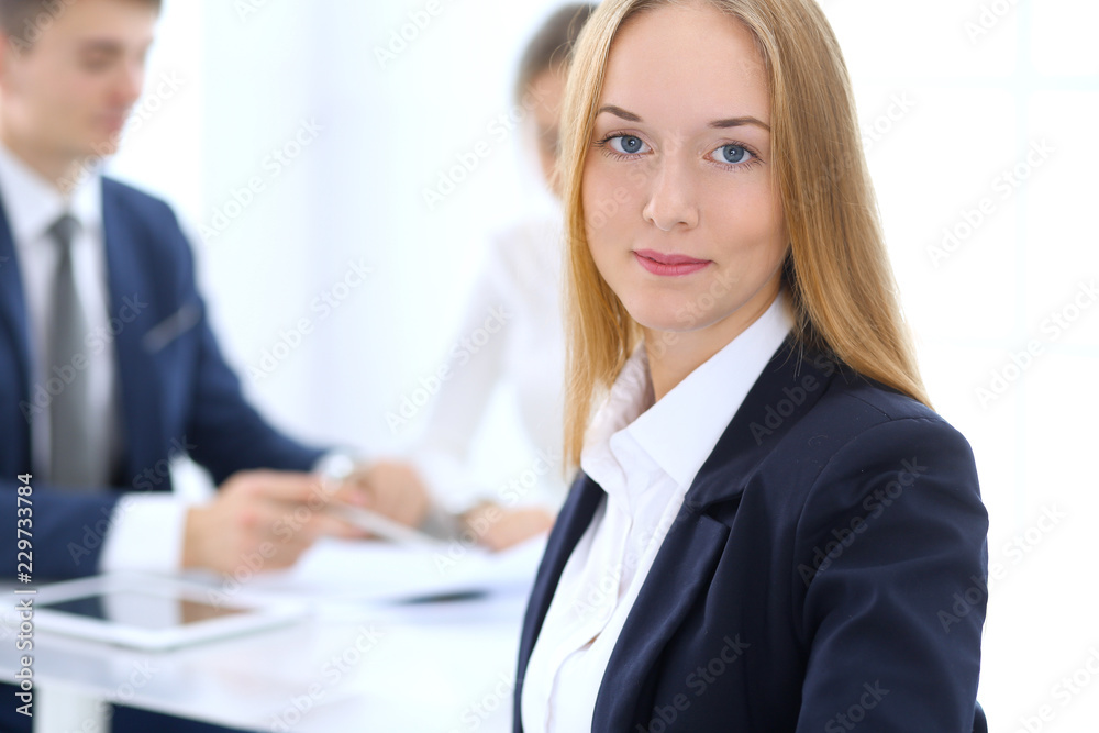 Group of business people or lawyers discussing terms of transaction in office. Focus at young business woman. Meeting and teamwork concept