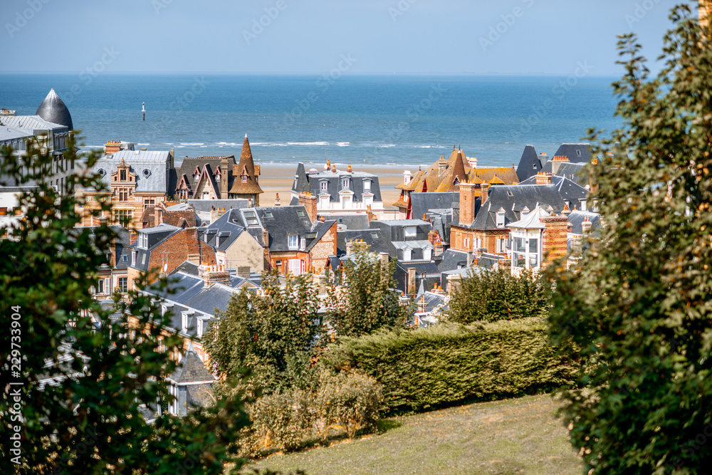 Top view of Trouville city with rooftops of luxury houses and ocean on the background in France