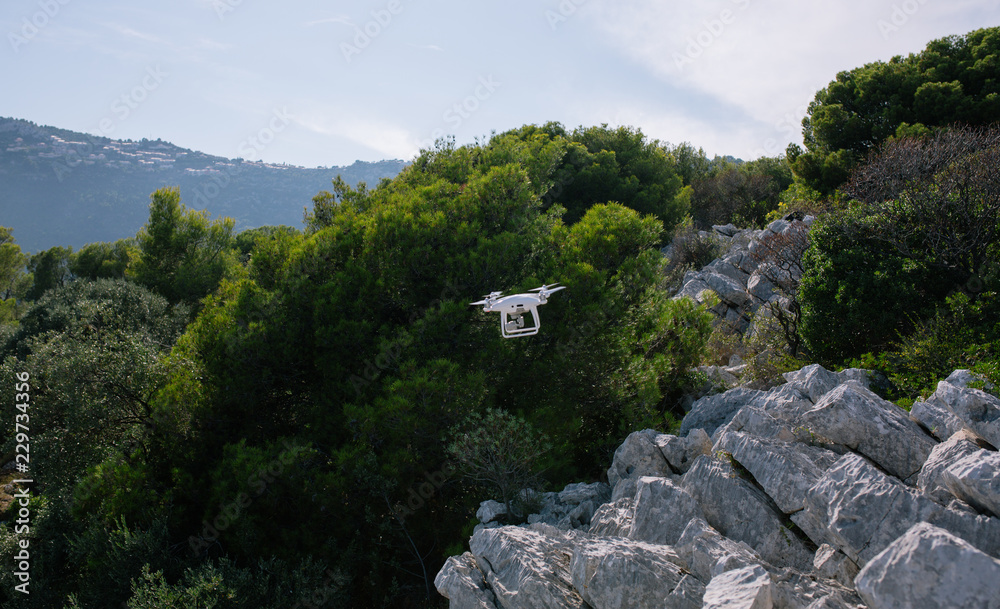 Drone, flyingon the white rocks against the blue sky quadrocopter fpv fly camera rc controller
