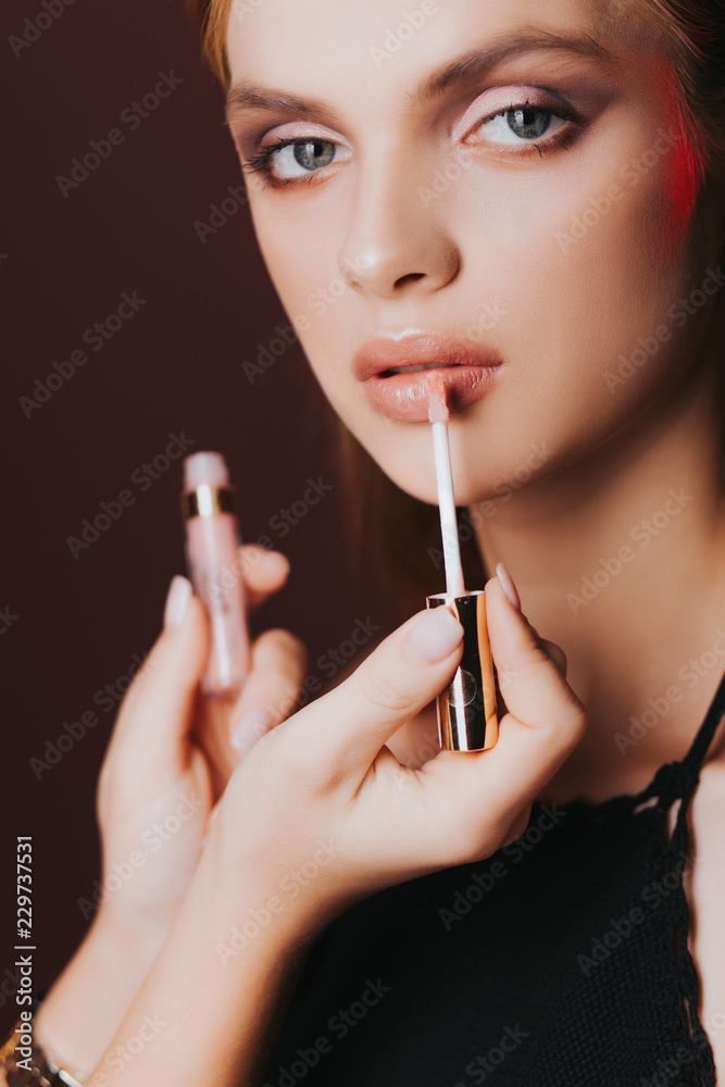 Fototapeta premium Lips. Skin care. Pomade. Portrait. Stylish makeup. Рortrait of beautiful young woman with clean and fresh skin. Nude makeup. Concept for cosmetology ads with copy space, beauty magazine and spa.