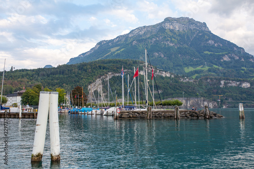 Lake port in Switzerland with white wooden shipyards lanterns and red flags photo