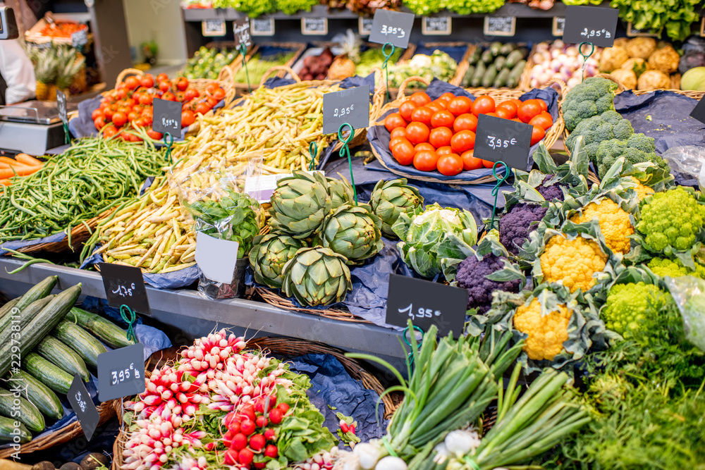 Variety of beautifully organized fruits and vegetables on the counter of the market place