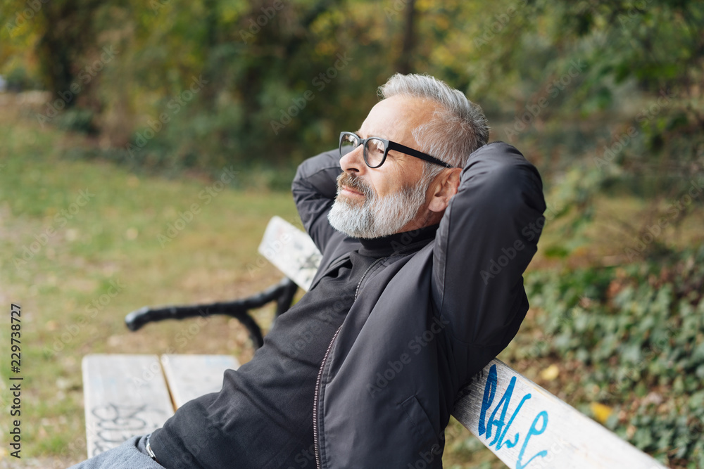 © contrastwerkstatt - Man relaxing on a park bench with closed eyes © contrastwerkstatt - Man relaxing on a park bench with closed eyes