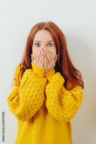 Shocked young woman staring wide-eyed at camera