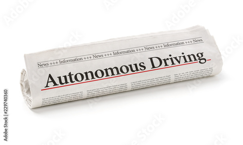 Rolled newspaper with the headline Autonomous Driving