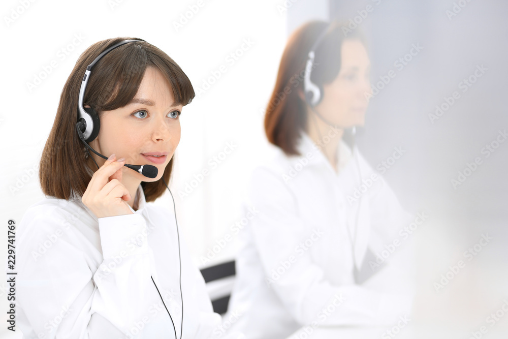 Call center. Group of operators at work. Focus on young brunette woman. Business  concept