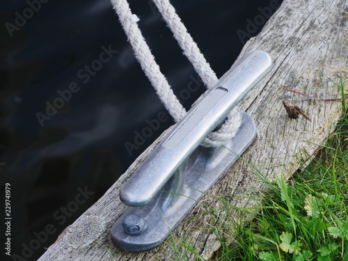 Photography Mooring cleat made of light alloy aluminum mounted on a wooden beam at a yetty f