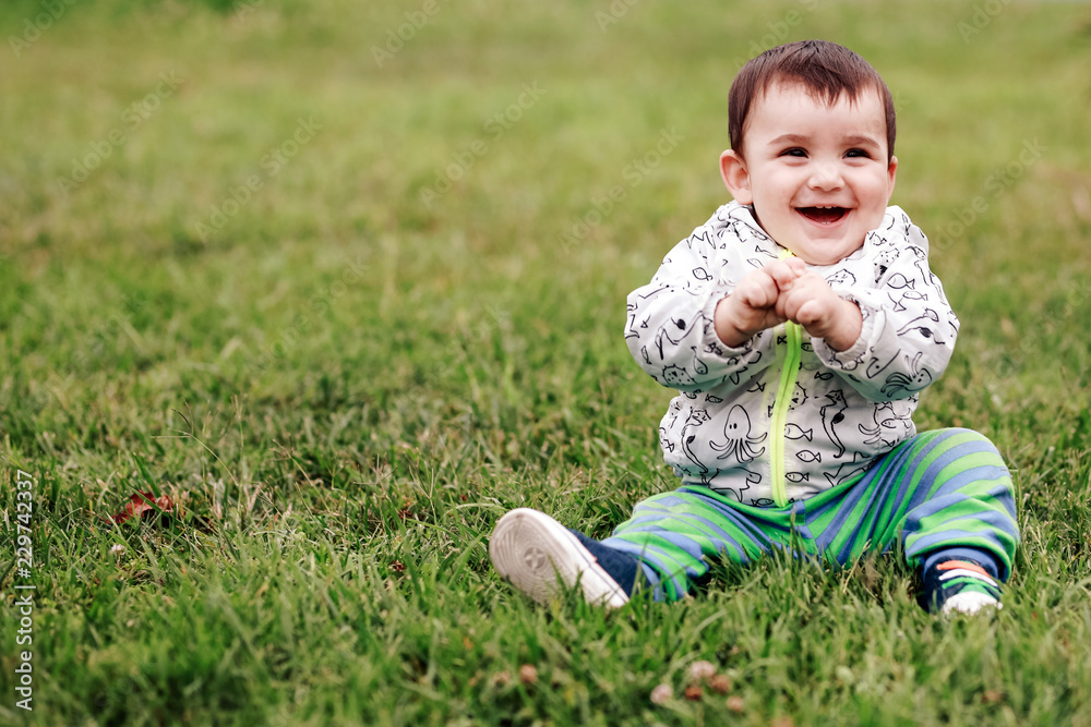 first steps of cute baby boy on footpath among greens first steps of cute baby boy on footpath among greens