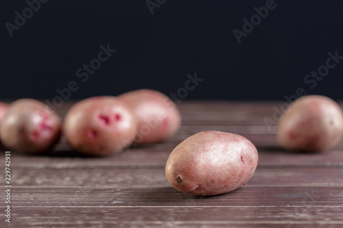 Fresh potatoes on the wood background