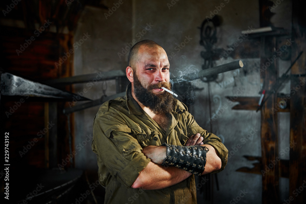 Portrait of a bearded hard worker. He smokes after hard work. Portrait of a bearded hard worker. He smokes after hard work.