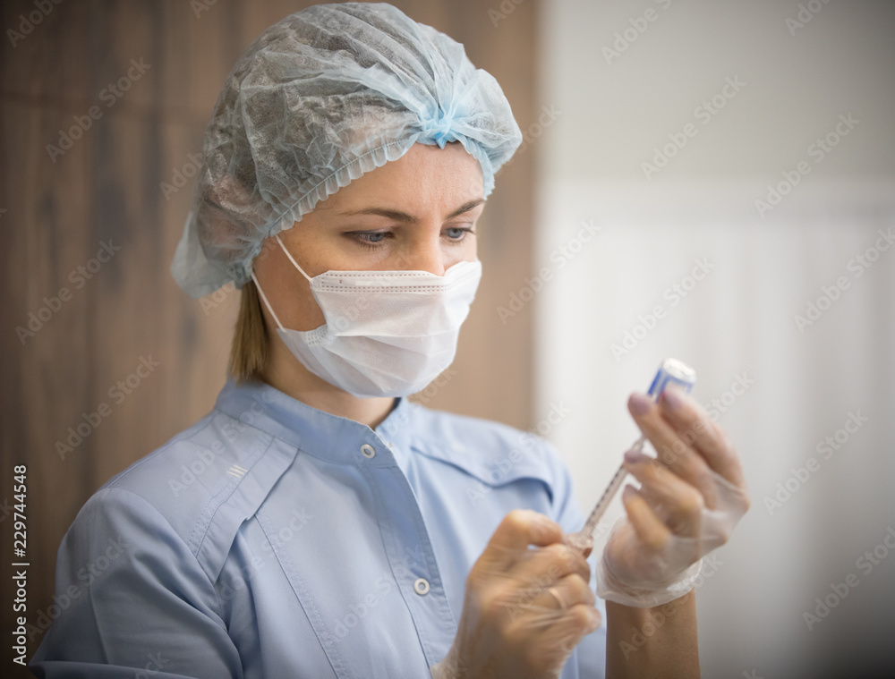 Woman in a cosmetology clinic. The specialist collects the substance in the syringe Woman in a cosmetology clinic. The specialist collects the substance in the syringe