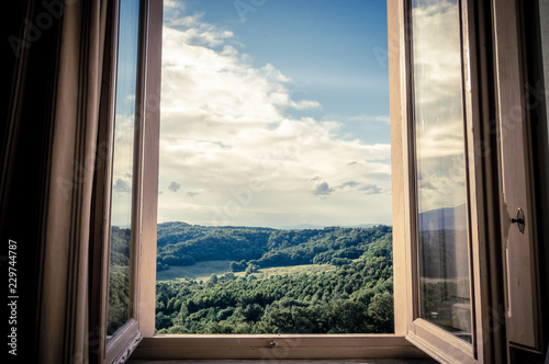Fototapeta Panoramiczny widok na wzgórza Chianti przez okno wczesnym rankiem