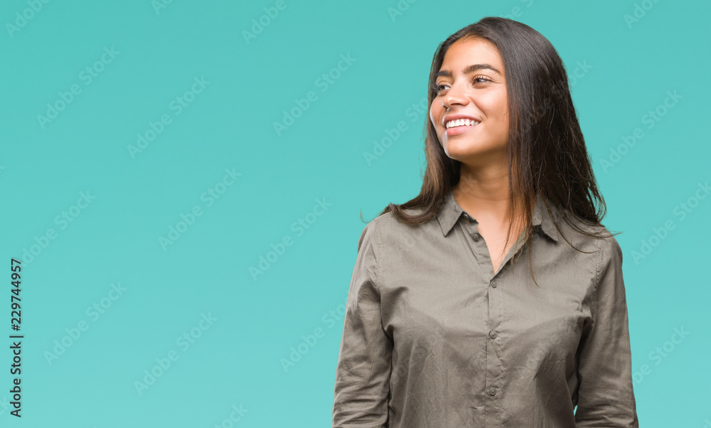 Obraz premium Young beautiful arab woman over isolated background looking away to side with smile on face, natural expression. Laughing confident.