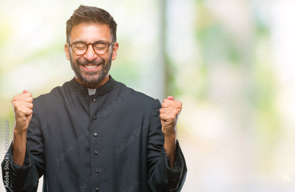 Adult hispanic catholic priest man over isolated background excited for success with arms raised celebrating victory smiling. Winner concept. Adult hispanic catholic priest man over isolated background excited for success with arms raised celebrating victory smiling. Winner concept.