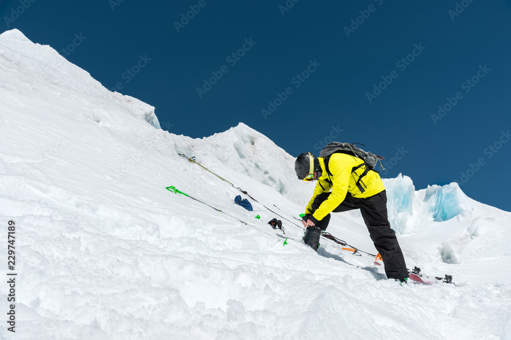 A professional skier standing on a glacier is preparing for a jump while setting up ski equipment. The concept of quality training for the sport