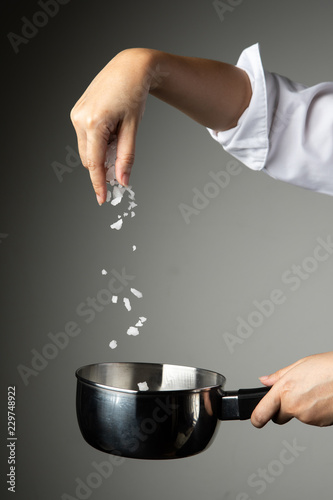 chef woman sprinkle salt cooking prepare food seasoning on grey background