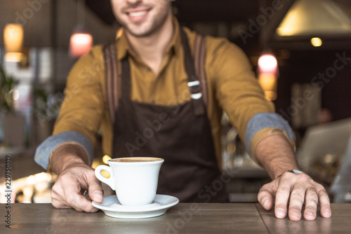 cropped shot of young barista with cup of delicious coffee