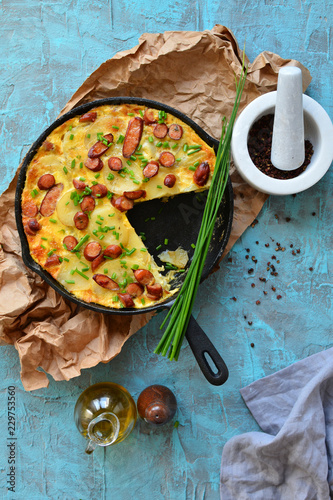 Overhead view of paella in pan with potatoes and sausages photo