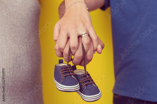 couple holding newborn baby shoes