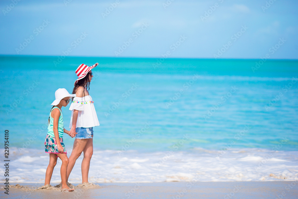 Beautiful mother and daughter on Caribbean beach. Family on beach vacation