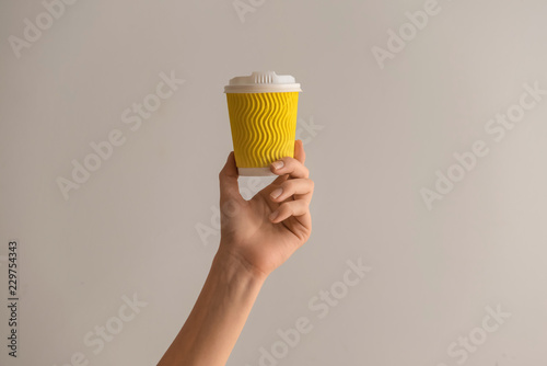 Woman holding paper coffee ...