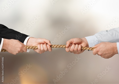 Tug war, two businessman pulling a rope