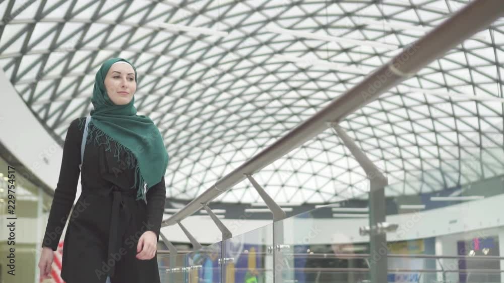 Pretty muslim woman in a hijab with a backpack goes to the store,slow mo Pretty muslim woman in a hijab with a backpack goes to the store,slow mo