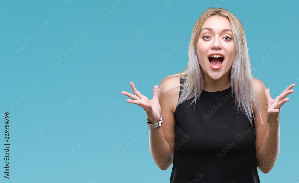 Young blonde woman over isolated background celebrating crazy and amazed for success with arms raised and open eyes screaming excited. Winner concept
