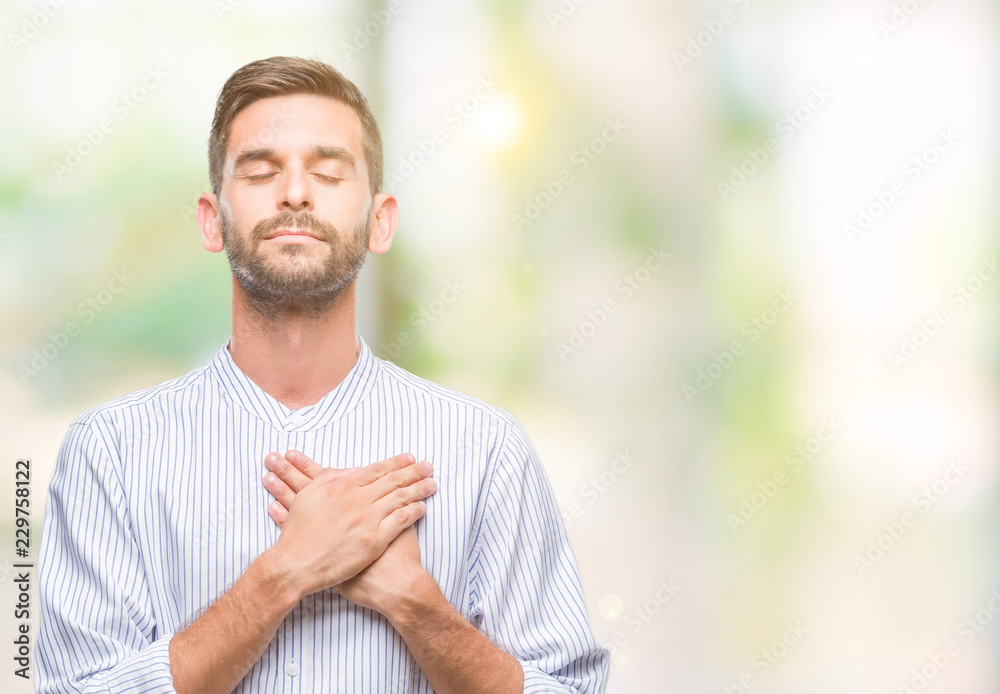Young handsome man over isolated background smiling with hands on chest with closed eyes and grateful gesture on face. Health concept.
