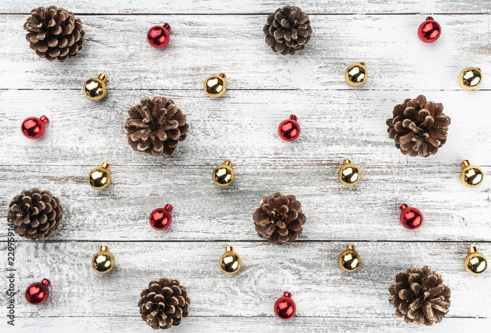 Old wooden Christmas background. Red and gold baubles and cones. Top view. Old wooden Christmas background. Red and gold baubles and cones. Top view.