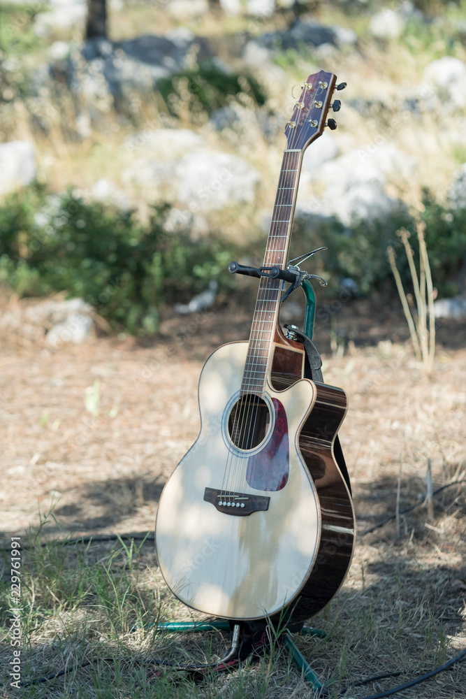 acoustic guitar supported on foot