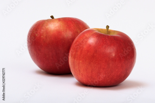 Two ripe red apples on a white background