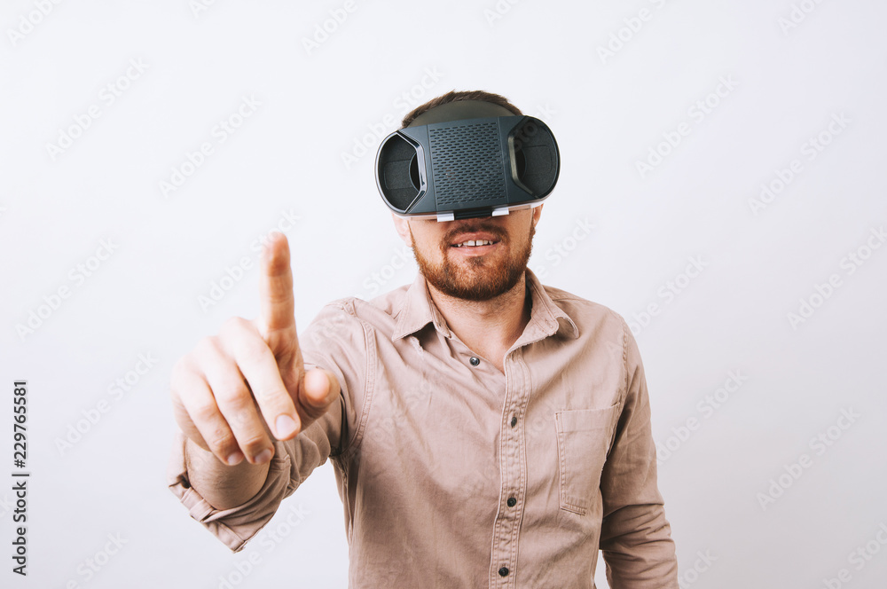 Young man in casual using VR - virtual reality gear and touching something over white background Young man in casual using VR - virtual reality gear and touching something over white background