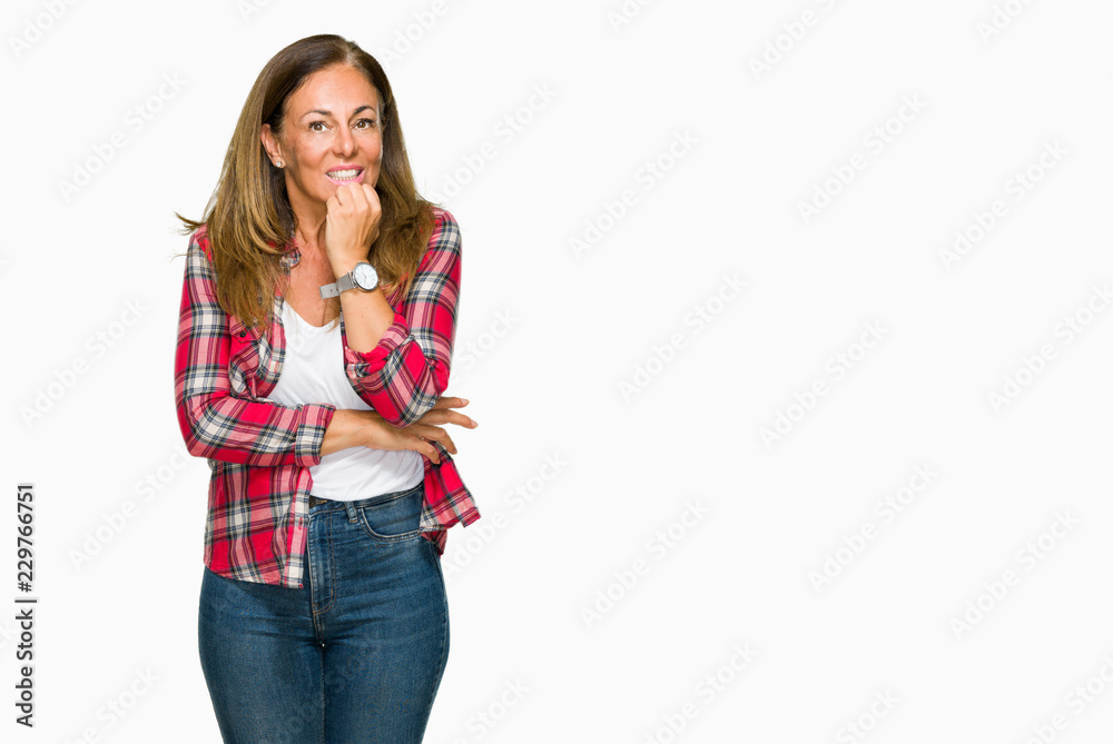 Middle age adult woman wearing casual shirt over isolated background looking stressed and nervous with hands on mouth biting nails. Anxiety problem. Middle age adult woman wearing casual shirt over isolated background looking stressed and nervous with hands on mouth biting nails. Anxiety problem.