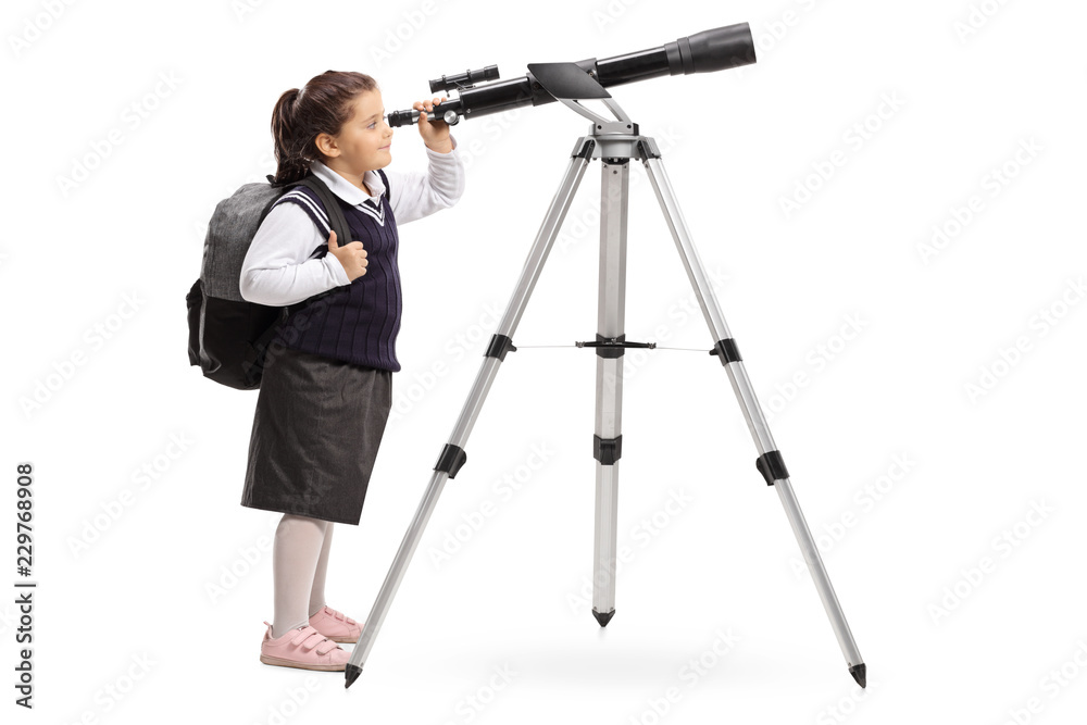 Schoolgirl in a uniform looking through a telescope