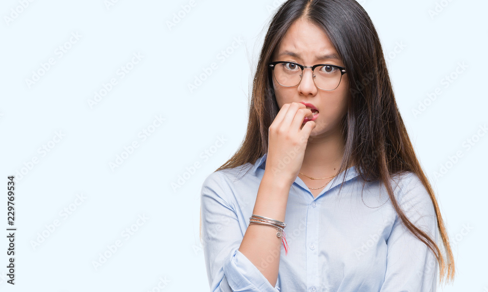 Young asian business woman wearing glasses over isolated background looking stressed and nervous with hands on mouth biting nails. Anxiety problem. Young asian business woman wearing glasses over isolated background looking stressed and nervous with hands on mouth biting nails. Anxiety problem.