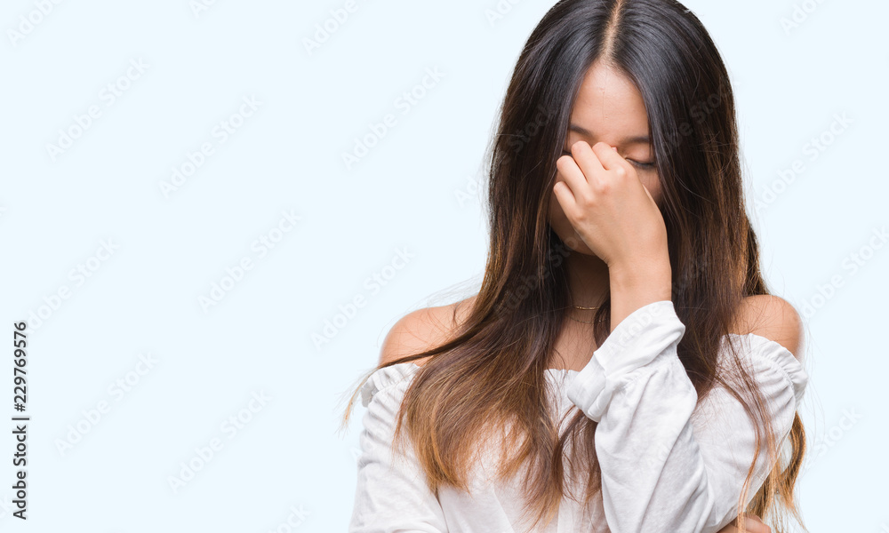 Young asian woman over isolated background tired rubbing nose and eyes feeling fatigue and headache. Stress and frustration concept. Young asian woman over isolated background tired rubbing nose and eyes feeling fatigue and headache. Stress and frustration concept.