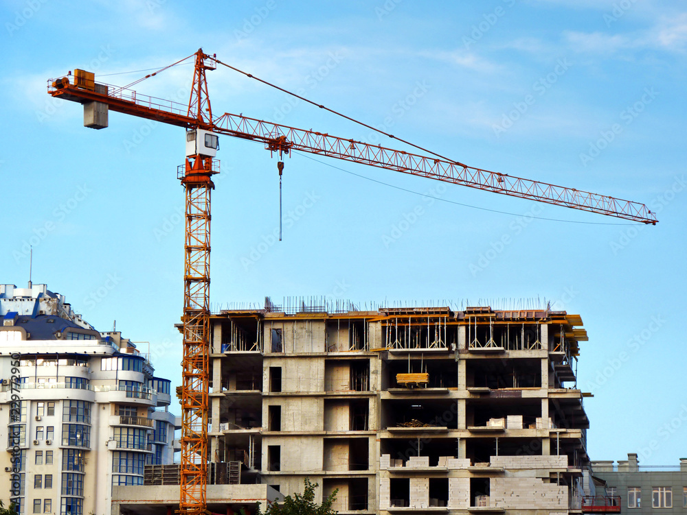 Construction site background. Self-erection crane near building.