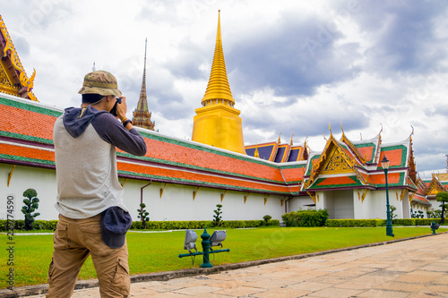 Photography Back side of young Asian male tourist backpackers photo in Wat Phra Kaew, Bangkok, Thailand on holidays
