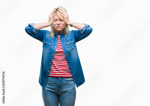 Young beautiful blonde woman wearing denim jacket over isolated background suffering from headache desperate and stressed because pain and migraine. Hands on head.