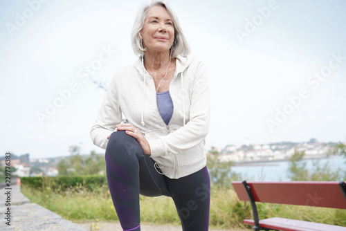  Senior woman stretching outdoors before running photo