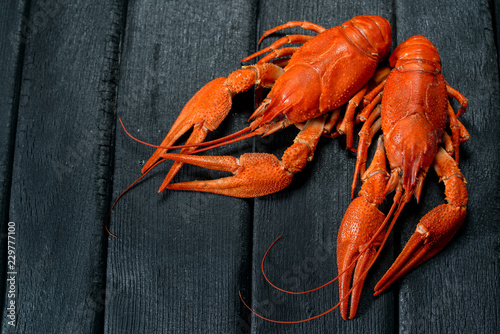  sweet boiled crayfish on a charred wooden black background