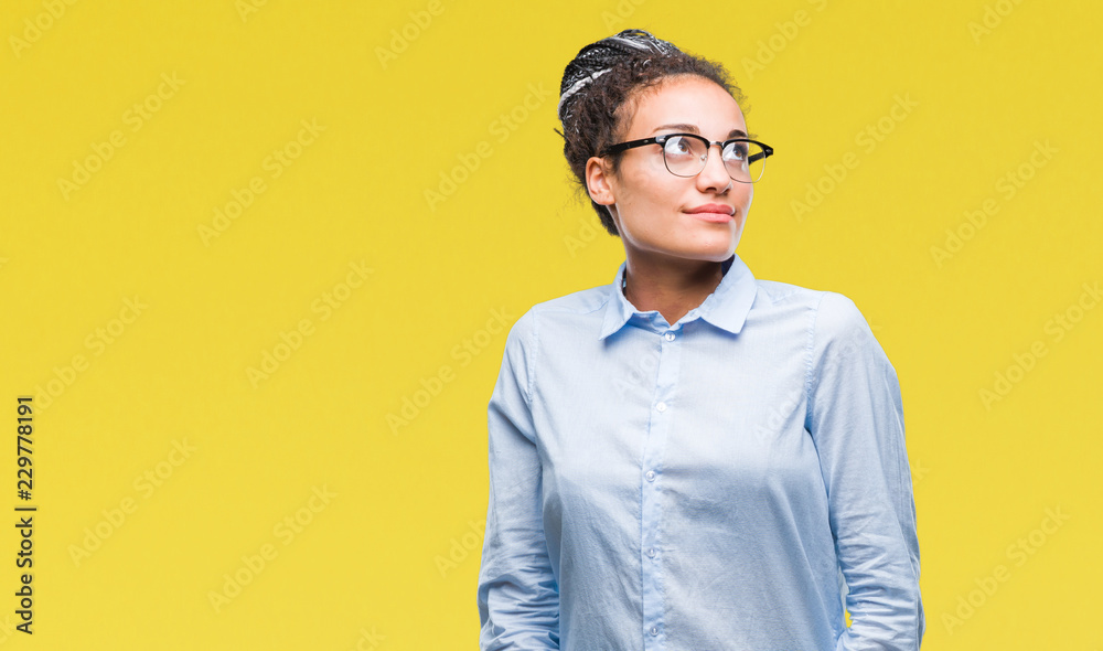 Young braided hair african american business girl wearing glasses over isolated background smiling looking side and staring away thinking. Young braided hair african american business girl wearing glasses over isolated background smiling looking side and staring away thinking.