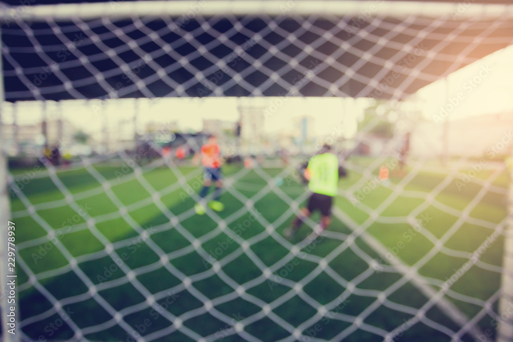 Fototapeta premium Mesh of goal with blurry football player.
