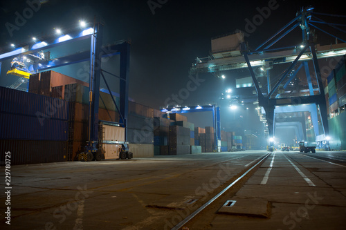 industrial port with containers. Stack of containers, gantry crane at night. Industrial Container yard for Logistic Import Export business.