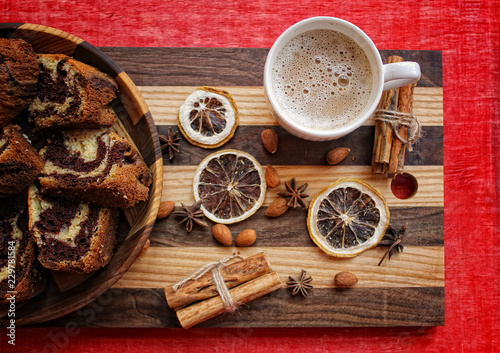 a cup of coffee and a marble cake in the wooden plate on the striped cutting Board with dry lemon,cinnamon 