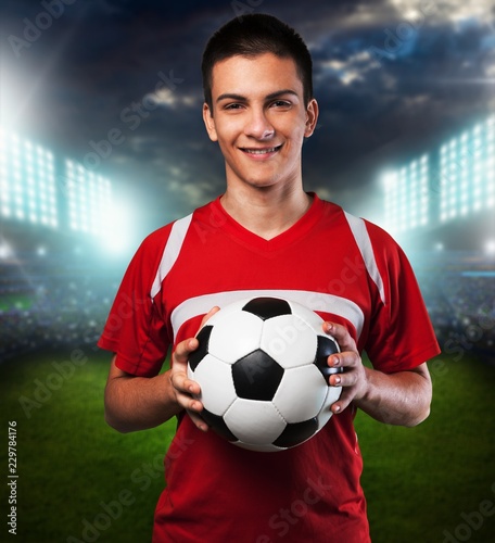 Soccer player is holding ball on  background © BillionPhotos.com
